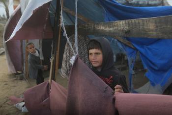 Children stand outside their temporary shelter in the Gaza Strip.