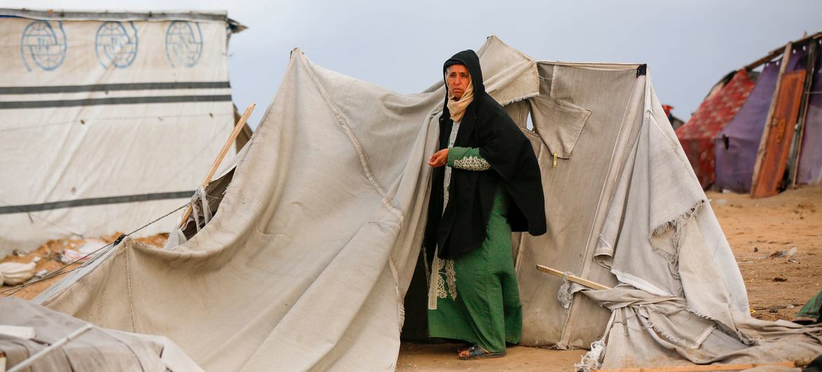 A woman stands by a tent in Gaza.