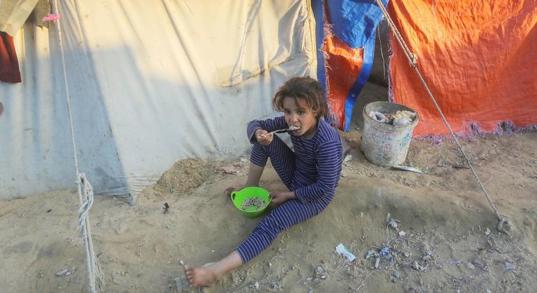 A child eats outside a temporary shelter in Gaza. 