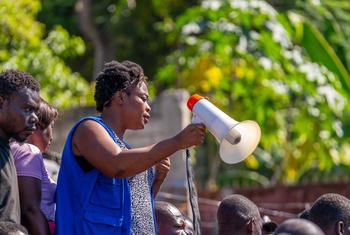 IOM staff member, Rose, supports displaced people as they pick up humanitarian supplies.