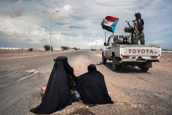 Soldiers drive at speed past two women begging in Lahj, Yemen.