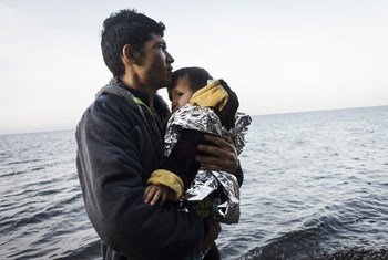 A young refugee from Afghanistan holds his young son and looks at the sea after reaching safely the shores of Lesbos island, having crossed the Aegean sea from Turkey in an inflatable boat full of Afghan refugees (file)