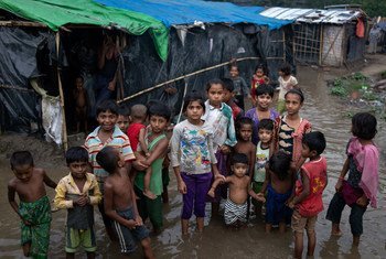 Pictured here, Rohingya refugee children wade through flood waters surrounding their families' shelters following an intense pre-monsoon storm in Shamlapur makeshift settlemen in Cox's Bazar district, Bangladesh.