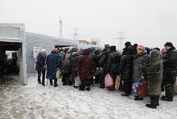 People wait in line at Maiorske Entry/Exit Checkpoint in eastern Ukraine
