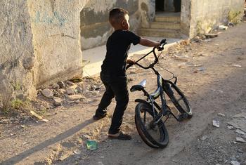 A child plays in front of his destroyed home in the Jenin refugee camp, West Bank. 