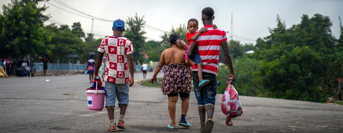 Members of a Haitian family return from the Dominican Republic carrying the few possessions they have.