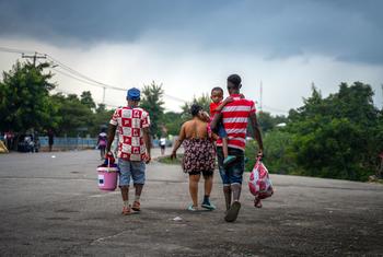 Members of a Haitian family return from the Dominican Republic carrying the few possessions they have.